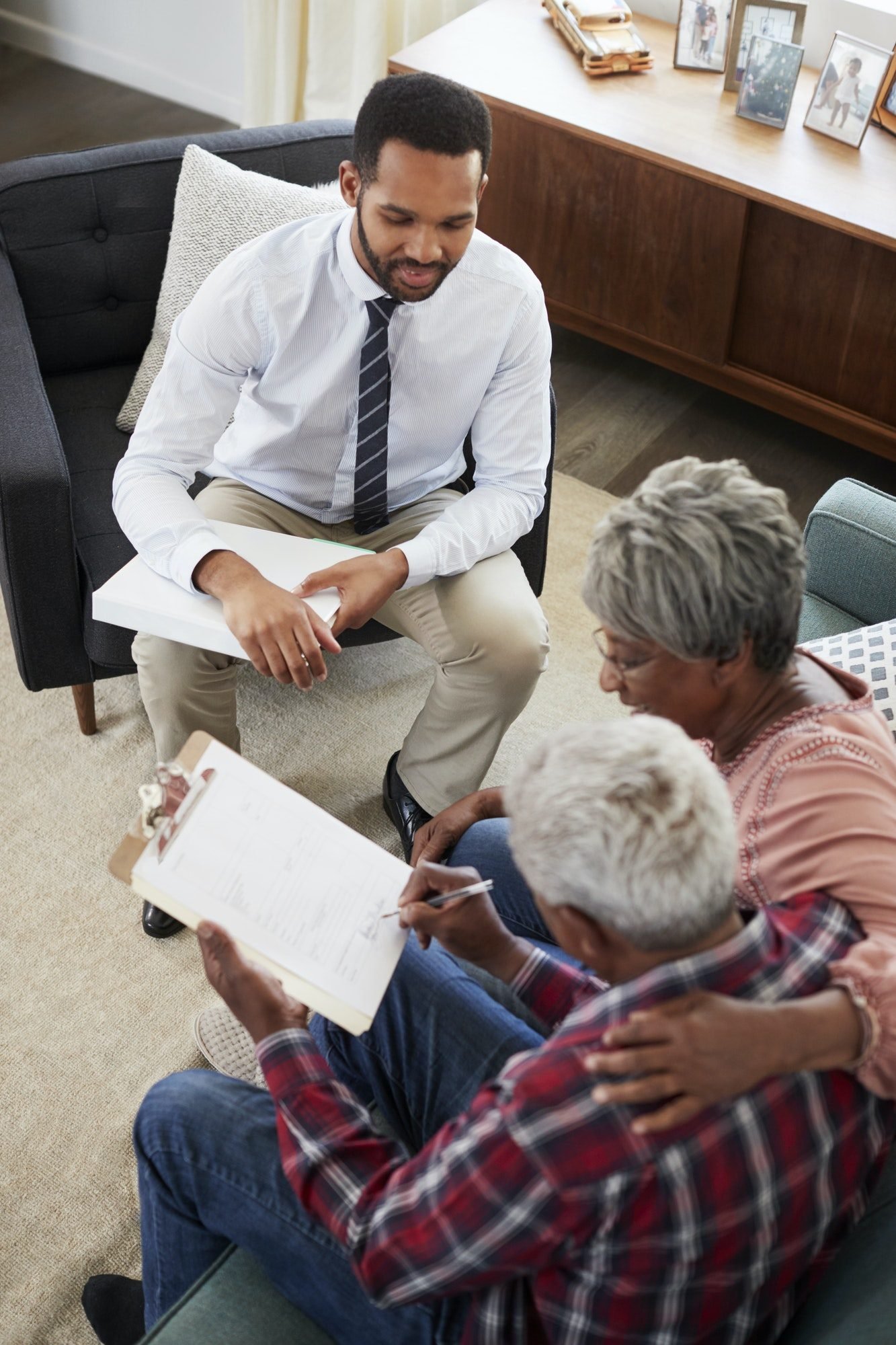 senior-couple-meeting-with-male-financial-advisor-at-home-and-signing-document.jpg